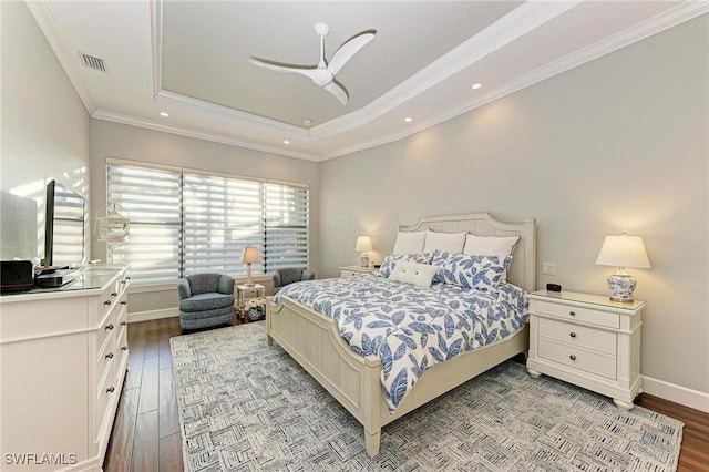 bedroom featuring ceiling fan, ornamental molding, a tray ceiling, and light wood-type flooring