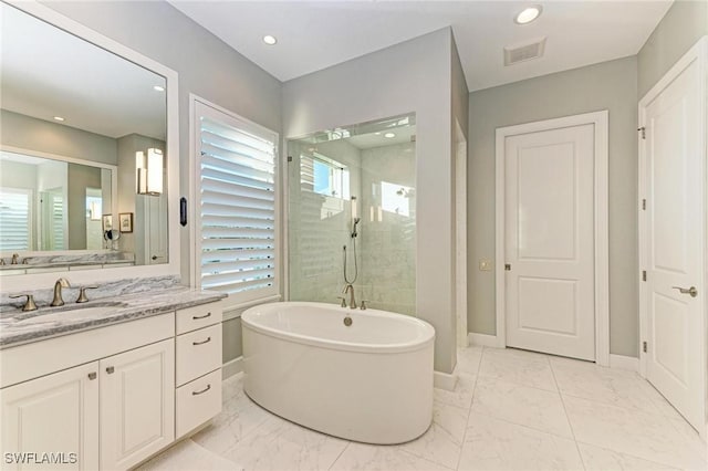 bathroom with vanity and shower with separate bathtub