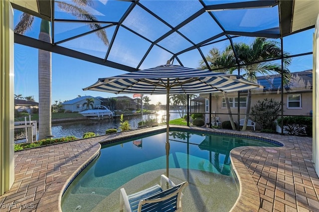 view of swimming pool featuring a water view, glass enclosure, and a patio area