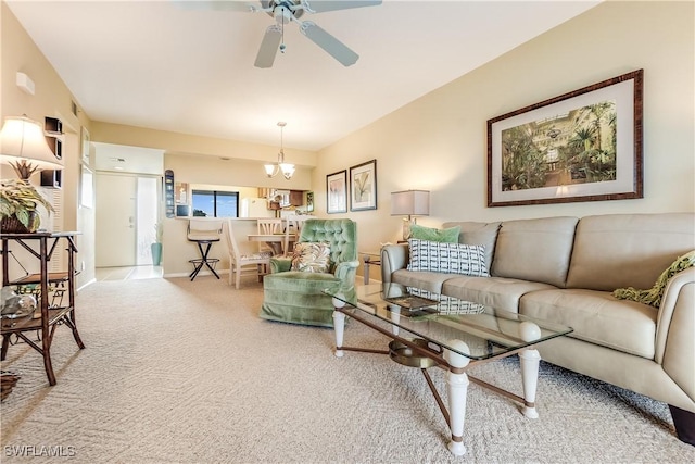 living room featuring ceiling fan with notable chandelier and light colored carpet