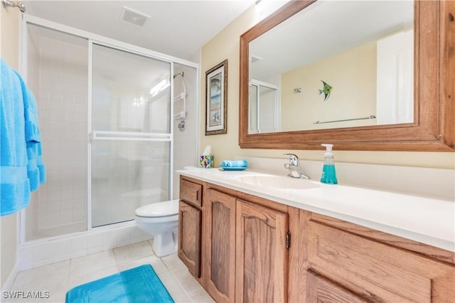 bathroom with tile patterned floors, vanity, toilet, and a shower with shower door