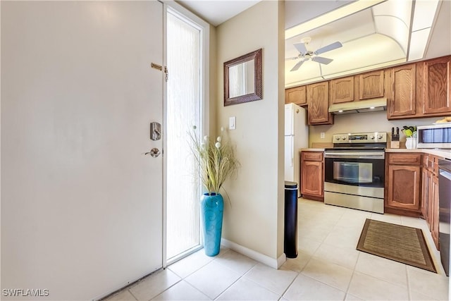 kitchen featuring ceiling fan, light tile patterned floors, and stainless steel appliances