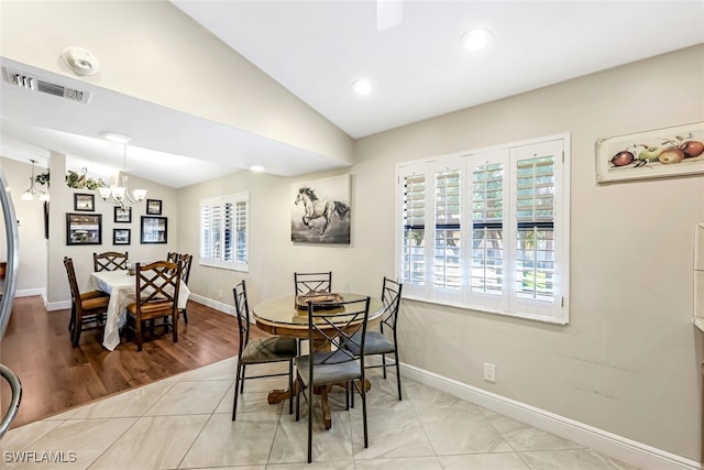 dining space featuring plenty of natural light, light hardwood / wood-style floors, and vaulted ceiling