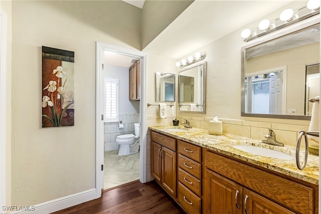 bathroom featuring toilet, vanity, tile walls, and hardwood / wood-style flooring