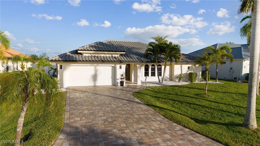 mediterranean / spanish-style home featuring a front yard and a garage