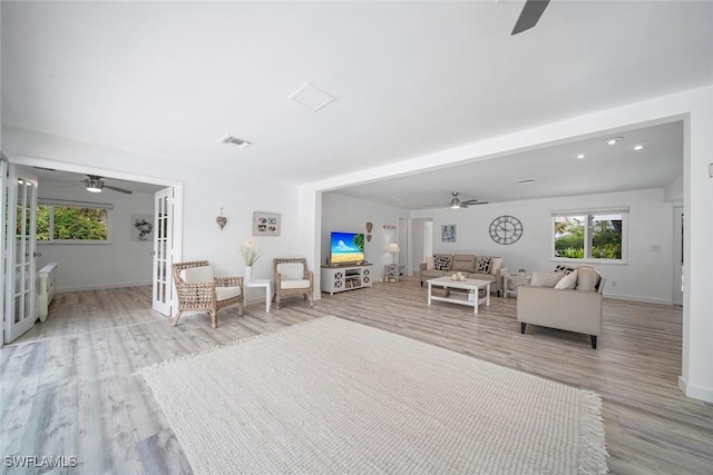 unfurnished living room featuring ceiling fan, french doors, and light hardwood / wood-style flooring