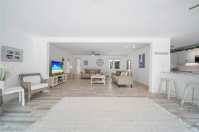 living room featuring light hardwood / wood-style floors and ceiling fan