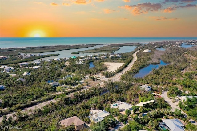 aerial view at dusk featuring a water view