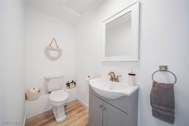 bathroom with hardwood / wood-style floors, vanity, and toilet