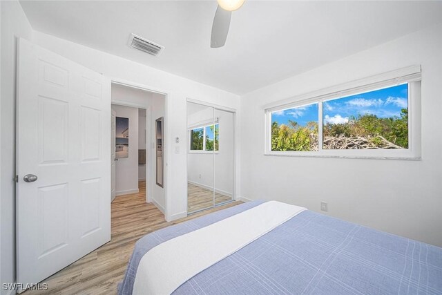 bedroom with ceiling fan, a closet, and light hardwood / wood-style floors