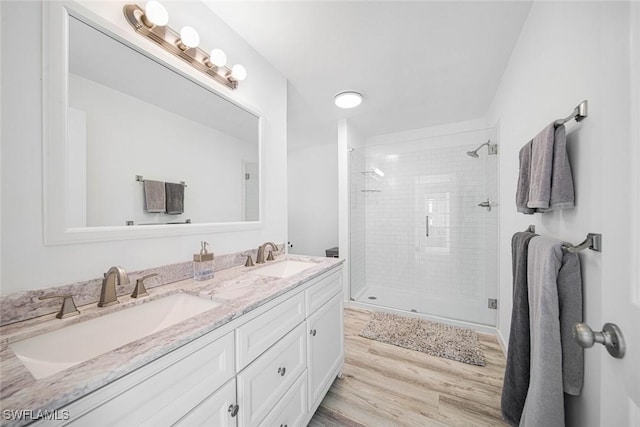 bathroom with hardwood / wood-style floors, vanity, and walk in shower