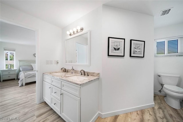 bathroom featuring toilet, vanity, and hardwood / wood-style flooring