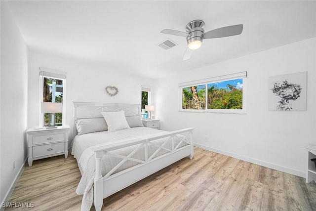 bedroom with multiple windows, ceiling fan, and light hardwood / wood-style floors