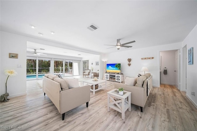 living room with ceiling fan and light hardwood / wood-style flooring