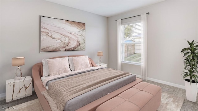 bedroom with light colored carpet and baseboards