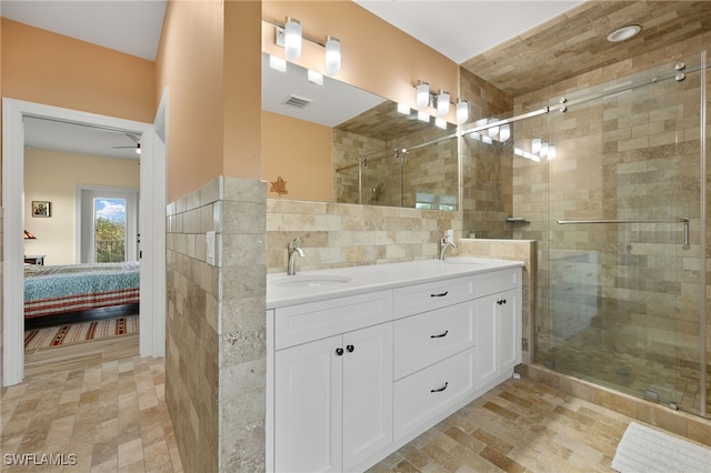 bathroom with vanity, ceiling fan, and an enclosed shower