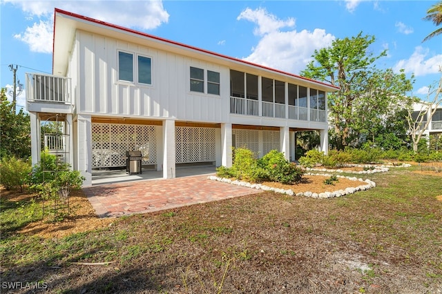 rear view of property with a patio area and a sunroom