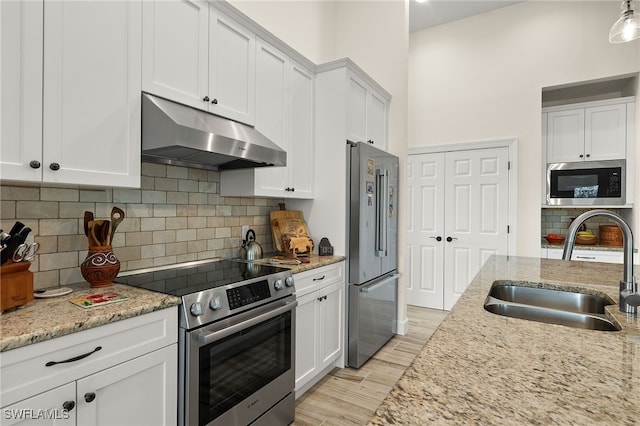 kitchen with sink, white cabinets, light hardwood / wood-style flooring, and appliances with stainless steel finishes