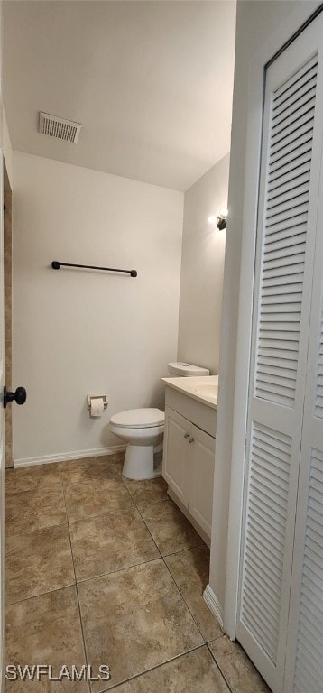 bathroom with tile patterned flooring, vanity, and toilet