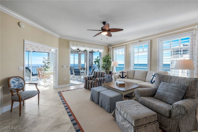 tiled living room featuring ornamental molding, a water view, ceiling fan, and a healthy amount of sunlight