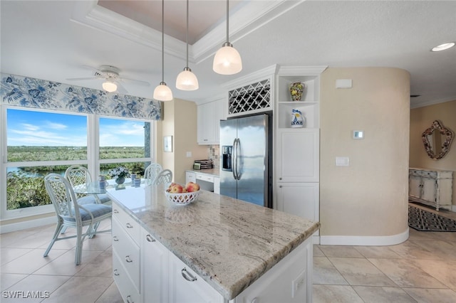 kitchen featuring a center island, white cabinets, stainless steel refrigerator with ice dispenser, ceiling fan, and decorative light fixtures