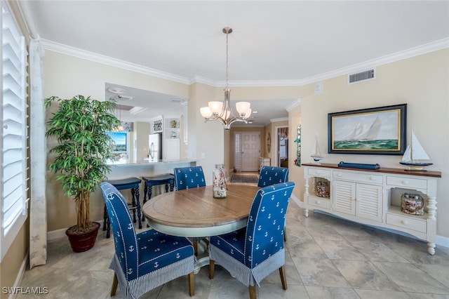 dining area featuring crown molding and a chandelier