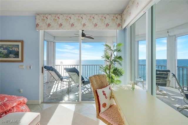 tiled dining room with a water view and ceiling fan