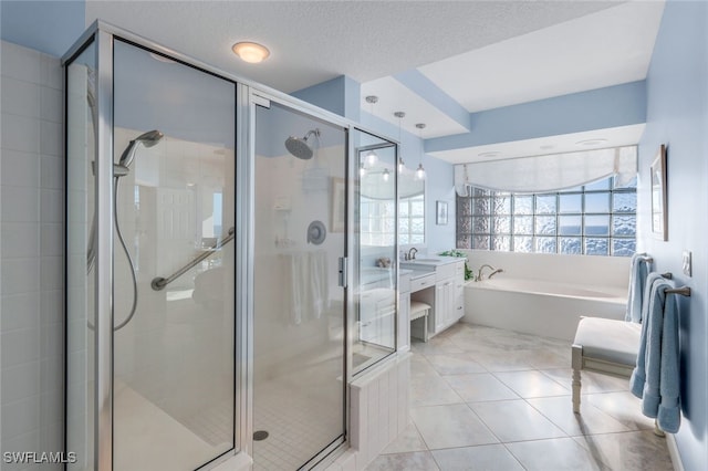 bathroom with tile patterned floors, vanity, shower with separate bathtub, and a textured ceiling