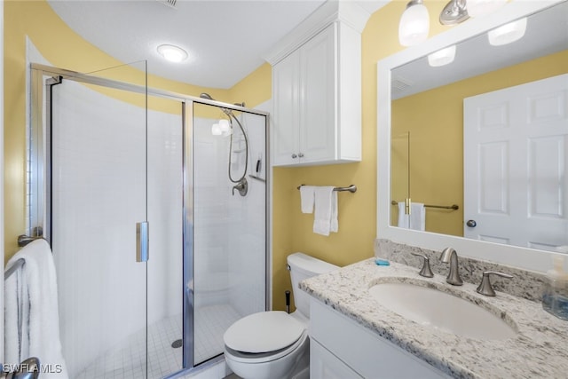 bathroom with vanity, toilet, and a shower with shower door