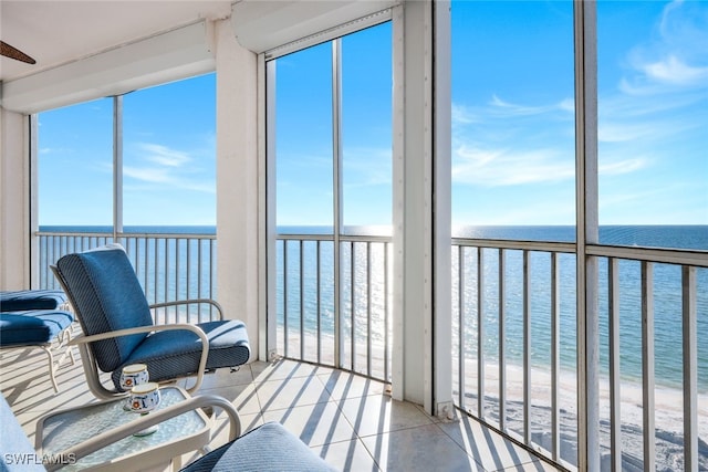 sunroom / solarium featuring plenty of natural light, a water view, and a beach view