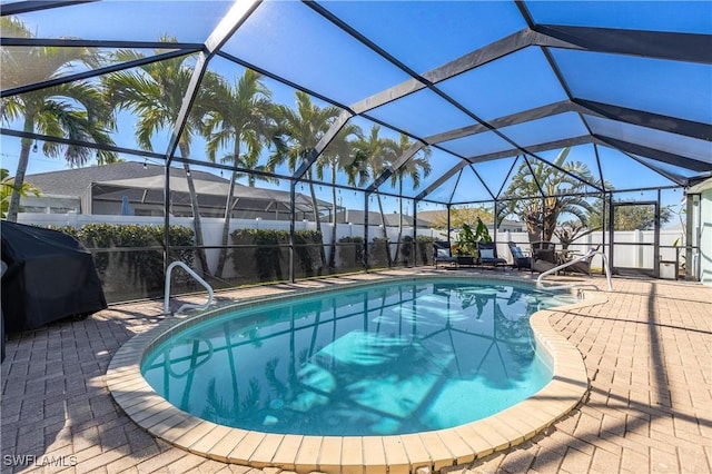 view of pool with a patio, a grill, and glass enclosure