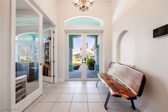 entryway featuring light tile patterned flooring, an inviting chandelier, and french doors