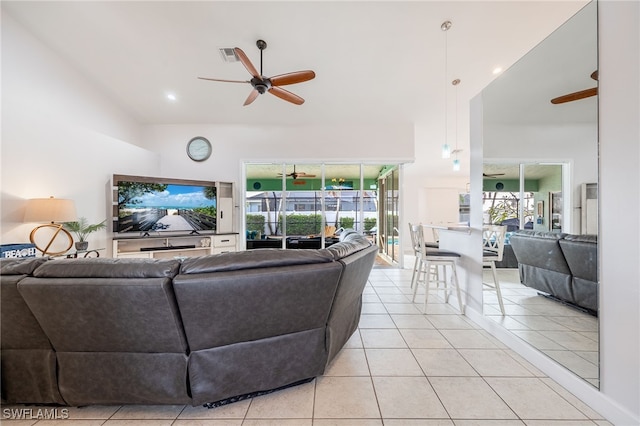 living room featuring a towering ceiling, light tile patterned floors, and ceiling fan