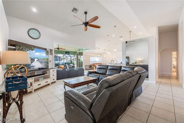 living room featuring ceiling fan, high vaulted ceiling, and light tile patterned floors