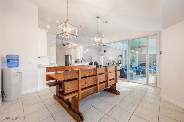 kitchen with stainless steel fridge with ice dispenser, hanging light fixtures, light tile patterned floors, ceiling fan with notable chandelier, and white cabinets