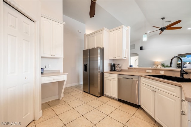 kitchen featuring sink, vaulted ceiling, light tile patterned floors, appliances with stainless steel finishes, and ceiling fan