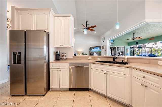 kitchen with sink, vaulted ceiling, light tile patterned floors, appliances with stainless steel finishes, and pendant lighting