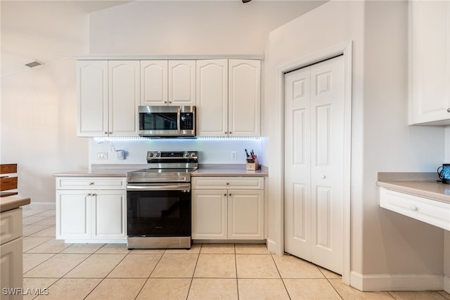 kitchen with white cabinetry, light tile patterned floors, and appliances with stainless steel finishes