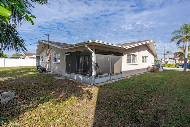 back of house featuring a sunroom and a yard