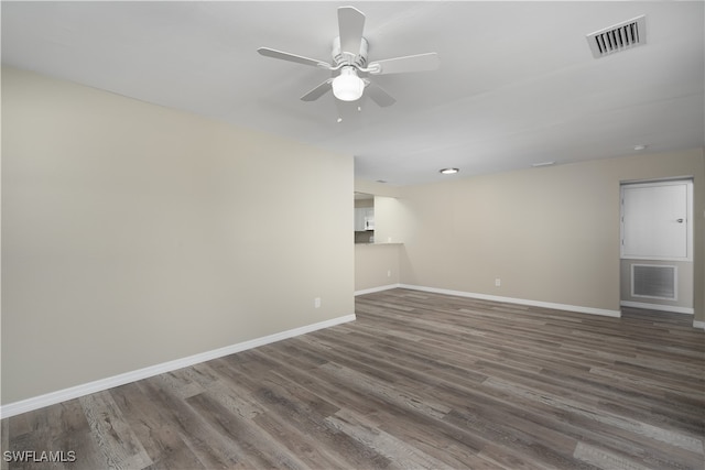 unfurnished living room featuring ceiling fan and dark wood-type flooring