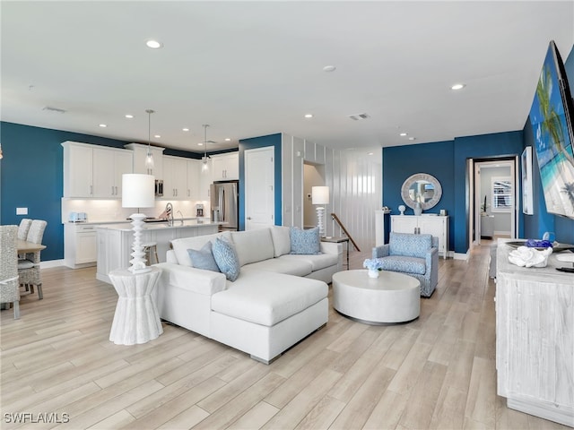 living room featuring light hardwood / wood-style flooring and sink