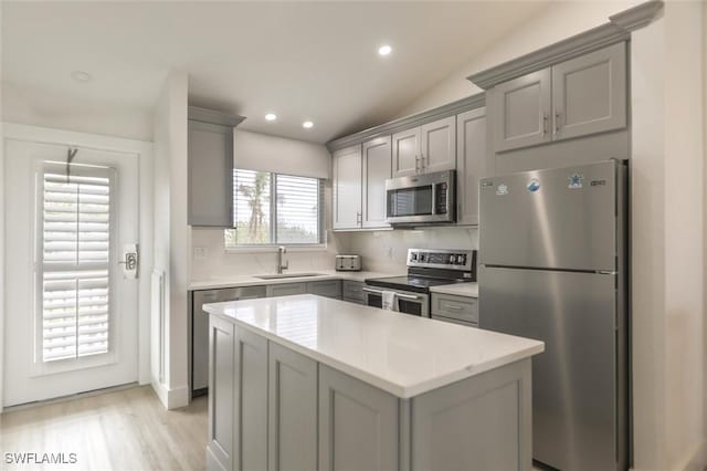 kitchen featuring sink, stainless steel appliances, tasteful backsplash, and vaulted ceiling