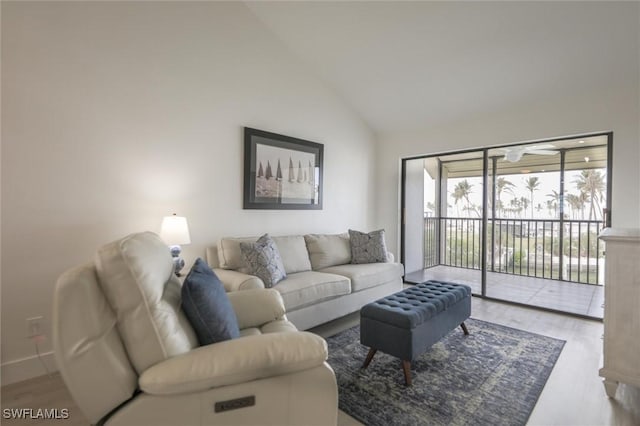 living room with light wood-type flooring and high vaulted ceiling