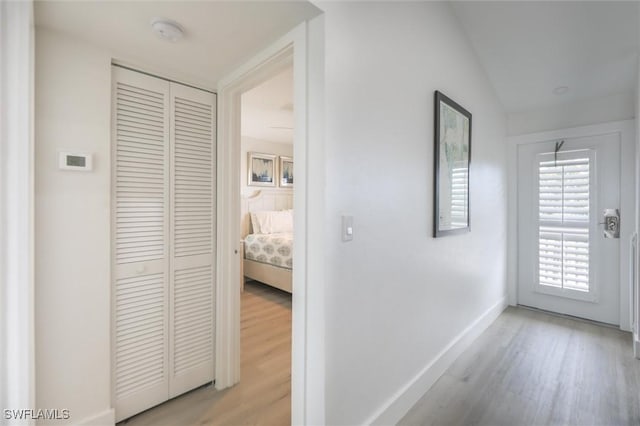 hall featuring light hardwood / wood-style flooring and vaulted ceiling