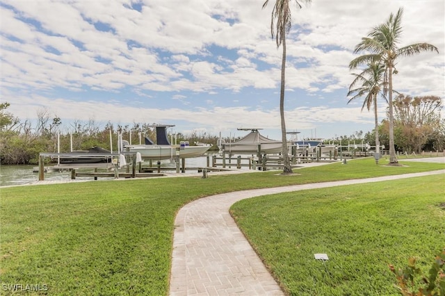 view of home's community featuring a boat dock, a water view, and a yard