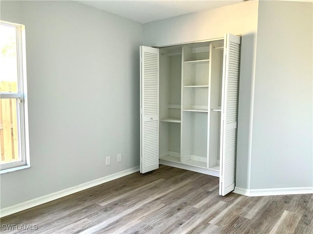 unfurnished bedroom with a closet and hardwood / wood-style floors