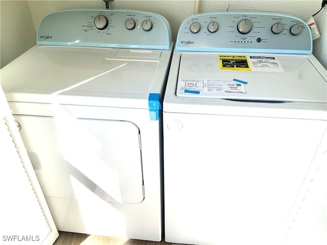 laundry area with hardwood / wood-style floors and washer and dryer