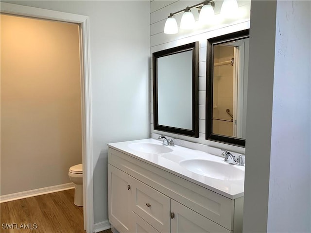 bathroom featuring vanity, hardwood / wood-style flooring, and toilet