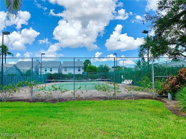 view of sport court with a lawn