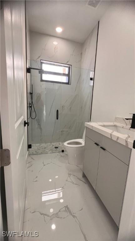 bathroom featuring vanity, toilet, and a shower with shower door